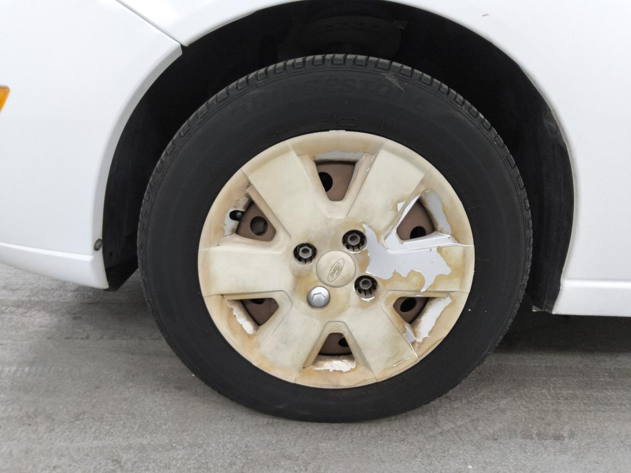 2007 Ford Focus Zx4 White vin: 1FAHP34N67W323181 Damage: Left Front Wheel Cover, Peeling, > 12 Inches