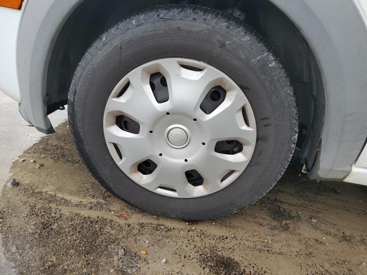 2013 Ford Transit Connect White vin: NM0LS7BN7DT136135 Damage: Left Front Wheel Cover, Peeling, 9 To 10 Inches